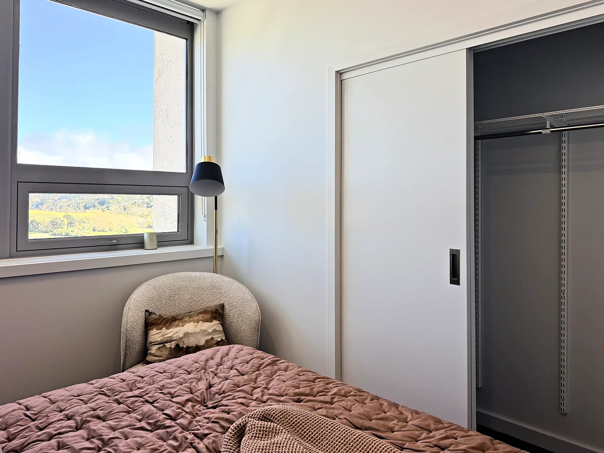 Built-in wardrobe with sliding door beside the bedroom window in a two bedroom corner display home at Avalon Apartments, Lower Hutt