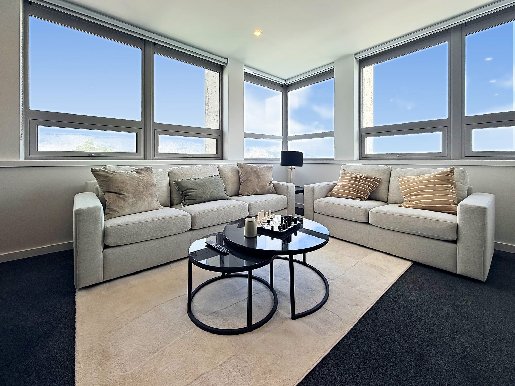 Sofas beneath corner windows in a two bedroom corner display home at Avalon Apartments, Lower Hutt